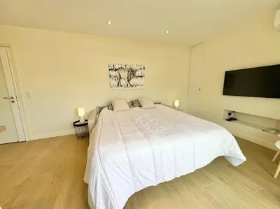 a bedroom with a white bed and a flat screen tv at Le studio Palm Beach, Clim ,Parking, Neuf in Cannes