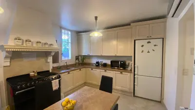 a kitchen with white cabinets and a black refrigerator at Cannes - proche des plages de la célèbre Croisette in Cannes