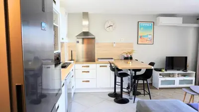 a kitchen with a small table and a kitchen with white cabinets at Appartement 426, vue mer et piscine by Palmazur in Cannes