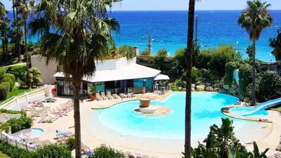 a swimming pool with the ocean in the background at Appartement 426, vue mer et piscine by Palmazur in Cannes
