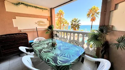 a table on a balcony with a view of the ocean at Appartement 426, vue mer et piscine by Palmazur in Cannes