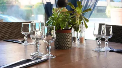 a table with wine glasses and a potted plant on it at Appartement 426, vue mer et piscine by Palmazur in Cannes