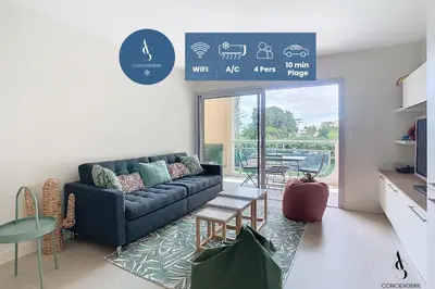 a living room with a couch and a table at Les Genêts - 2 chambres - Terrasse - Climatisé in Le Cannet