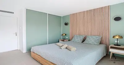 a bedroom with a bed with two pillows on it at Les Genêts - 2 chambres - Terrasse - Climatisé in Le Cannet