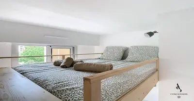 a bedroom with a large bed with a lamp at Les Genêts - 2 chambres - Terrasse - Climatisé in Le Cannet