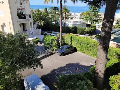 a car parked in a parking lot in front of a house at Grand T2 vue mer dans résidence de standing, parking, pointe croisette in Cannes
