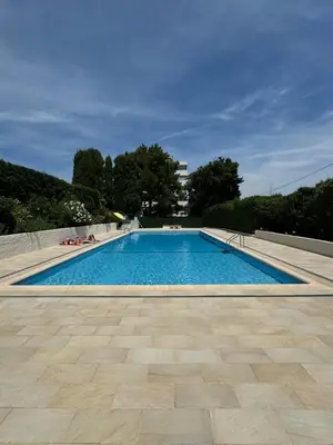 a large swimming pool with blue water at Studio neuf avec terrasse in Cannes