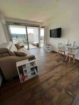 a living room with a couch and a table at Studio neuf avec terrasse in Cannes