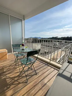 a glass table on a balcony with a view at Studio neuf avec terrasse in Cannes