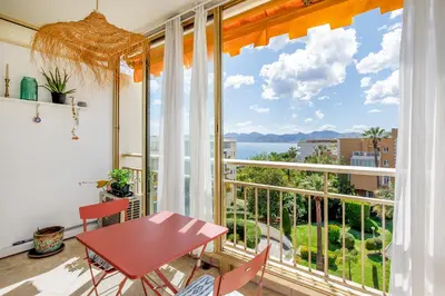 a room with a table and a large window at Cannes-vue mer Esterel-balcon-Plage in Cannes