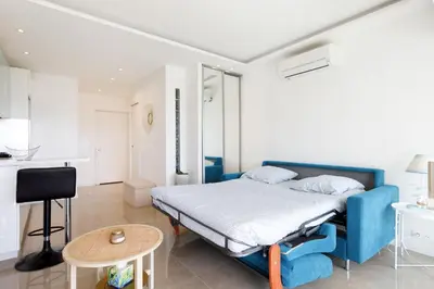 a bedroom with a blue bed and a table at Cannes-vue mer Esterel-balcon-Plage in Cannes
