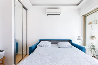 a bedroom with a bed with a blue headboard at Cannes-vue mer Esterel-balcon-Plage in Cannes