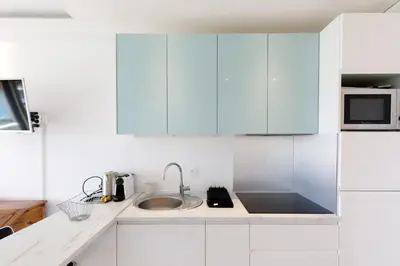 a white kitchen with a sink and a microwave at Cannes-vue mer Esterel-balcon-Plage in Cannes