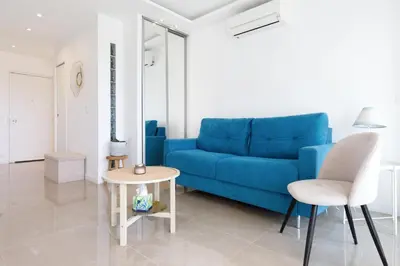 a living room with a blue couch and a table at Cannes-vue mer Esterel-balcon-Plage in Cannes