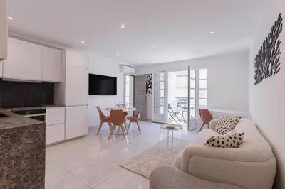 a kitchen and living room with a couch and a table at Cannes Molière - Palais, Plage, Balcon, Clim et Centre ville in Cannes