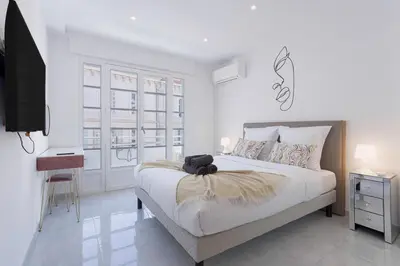 a bedroom with a bed with a teddy bear on it at Cannes Molière - Palais, Plage, Balcon, Clim et Centre ville in Cannes
