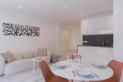 a white table and chairs in a living room at Cannes Molière - Palais, Plage, Balcon, Clim et Centre ville in Cannes