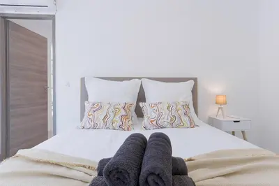a bedroom with a white bed with towels on it at Cannes Molière - Palais, Plage, Balcon, Clim et Centre ville in Cannes