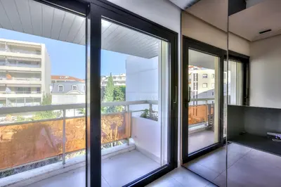 a room with large windows with a view of a city at Luxury 4 Stars Apt Croisette in Cannes