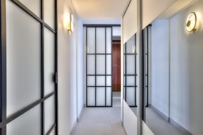an internal corridor with glass doors and a tile floor at Luxury 4 Stars Apt Croisette in Cannes