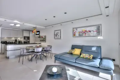 a living room with a blue couch and a kitchen at Luxury 4 Stars Apt Croisette in Cannes