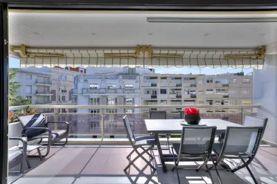 a balcony with a table and chairs and a large window at Luxury 4 Stars Apt Croisette in Cannes