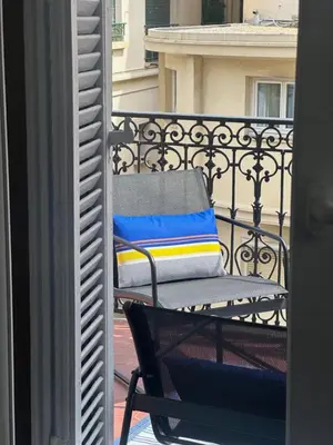 a chair on a balcony with a colorful pillow at Dolce Cannes Riviera Cannes in Cannes
