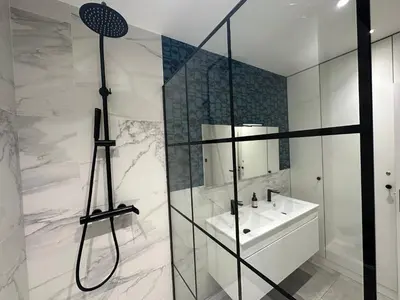 a white bathroom with a shower and a sink at Dolce Cannes Riviera Cannes in Cannes