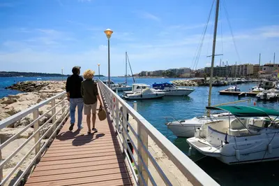 a man and woman walking on a wooden walkway near boats at CANNES - STUDIO proximité Mer et commerces in Cannes