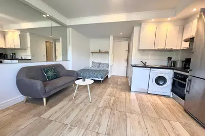 a living room with a couch and a table at CANNES - STUDIO proximité Mer et commerces in Cannes