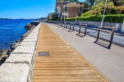 a wooden walkway next to the water with benches at CANNES - STUDIO proximité Mer et commerces in Cannes