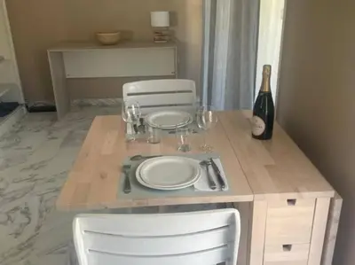 a table with two plates and a bottle of wine at Studio AC with Balcony by Olidesi in Cannes