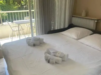 a white bed with towels on it with a balcony at Studio AC with Balcony by Olidesi in Cannes