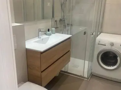 a bathroom with a sink and a washing machine at Studio AC with Balcony by Olidesi in Cannes