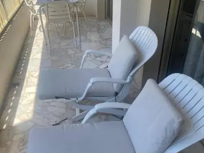 two white chairs and a table on a patio at Studio AC with Balcony by Olidesi in Cannes