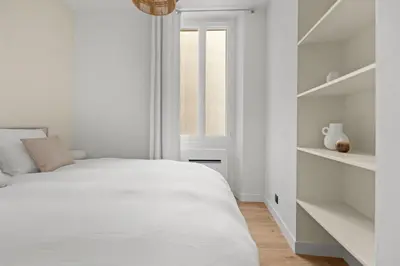 a white bedroom with a bed and a window at LB Vacation Rentals I Renovated Apartment Min from Beach and Palais in Cannes