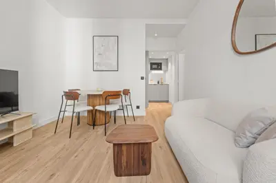 a living room with a white couch and a table at LB Vacation Rentals I Renovated Apartment Min from Beach and Palais in Cannes