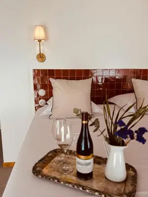 a bottle of wine and two glasses on a bed at Maison LYO logement Luxe in Cannes