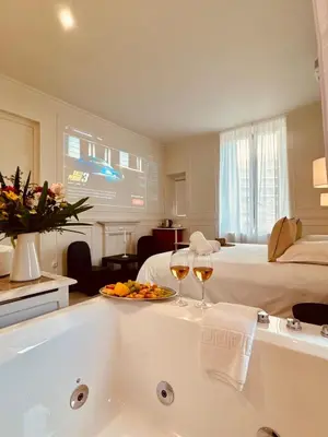 a hotel room with a tub and two glasses of wine at Maison LYO logement Luxe in Cannes