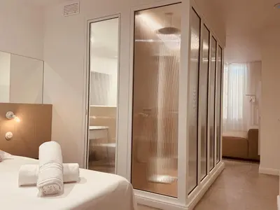 a bedroom with a glass shower with towels on a bed at Maison LYO logement Luxe in Cannes