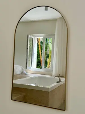 a mirror reflecting a bath tub in a bedroom at Maison LYO logement Luxe in Cannes