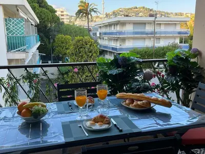a table with food and drinks on a balcony at Beau Soleil Standing Presta in Cannes