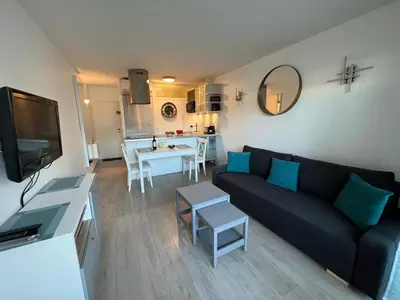 a living room with a black couch and a kitchen at Beau Soleil Standing Presta in Cannes