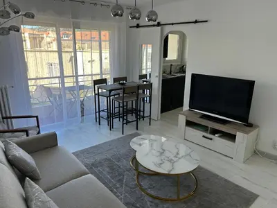 a living room with a couch and a flat screen tv at Marble elegancy in Cannes center in Cannes