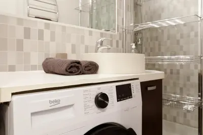a washing machine in a bathroom with a sink at Studio très spacieux et Design LE BELLA Climatisé in Cannes