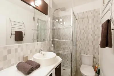a white bathroom with a sink and a toilet at Studio très spacieux et Design LE BELLA Climatisé in Cannes