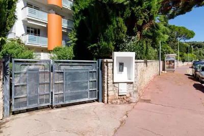 a gate on a sidewalk next to a building at Studio très spacieux et Design LE BELLA Climatisé in Cannes