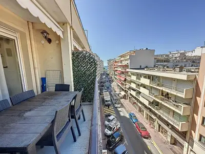 a balcony with a table and a view of a city at 57m2 - 2 chambres, terrasse, Croisette-Martinez in Cannes