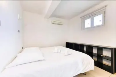 a white bedroom with a bed and a window at 57m2 - 2 chambres, terrasse, Croisette-Martinez in Cannes