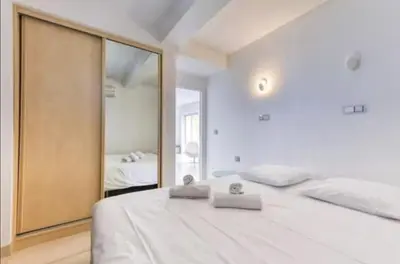 a bedroom with a large white bed and a large mirror at 57m2 - 2 chambres, terrasse, Croisette-Martinez in Cannes